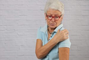 Woman Holder Her Should Due to Pain That May Indicate the Need for a Total Shoulder Replacement